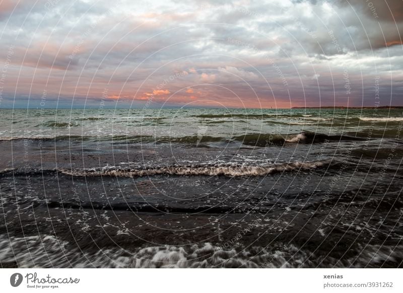 Sunset in the sky with clouds over the green water with waves Waves Baltic Sea Sky Clouds Horizon Vacation & Travel coast Ocean Evening Landscape Twilight Moody