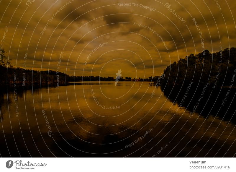 Small lake at sunset small lake lakes water sky cloud clouds shore sea shore reeds reflection water reflection trees nature Germany outside Outdoor color