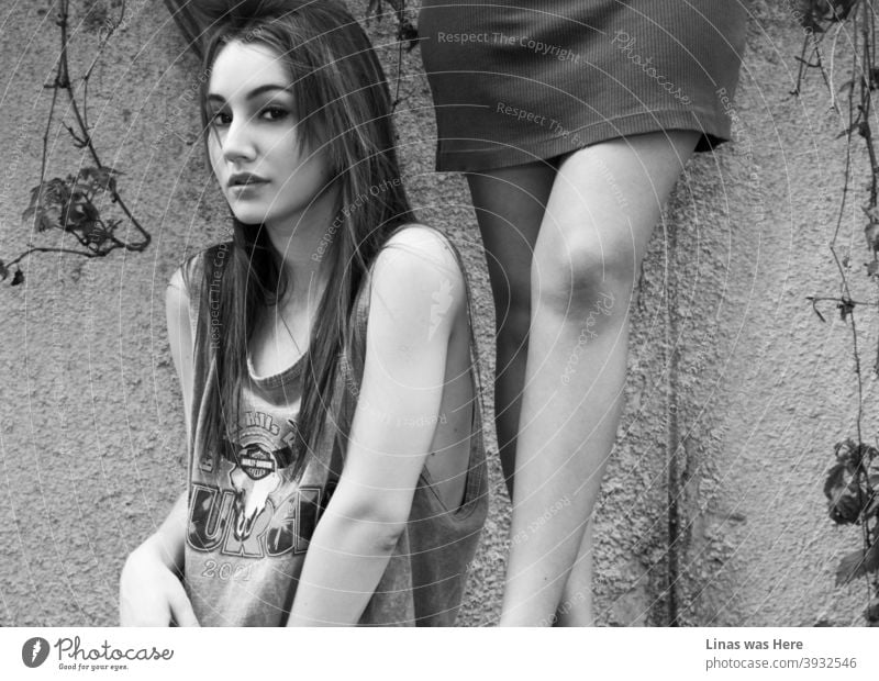 A gorgeous brunette model is looking straight into the camera. Her big black eyes are going straight through anything. Also, other models’ legs are right next to this beauty in the composition.