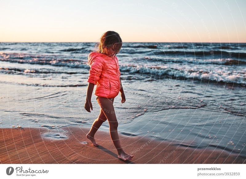 Little girl walking barefoot on a beach at sunset free enjoy positive emotion carefree nature outdoors travel happiness happy sea summer vacation leisure fun