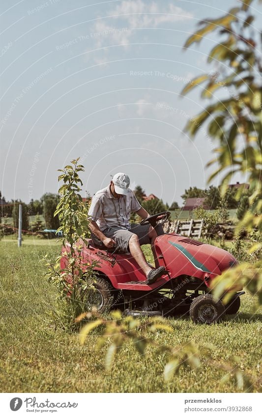 Man mowing his lawn using riding lawnmower occupation seasonal cut trimming man job person field professional ride gardener drive equipment worker male