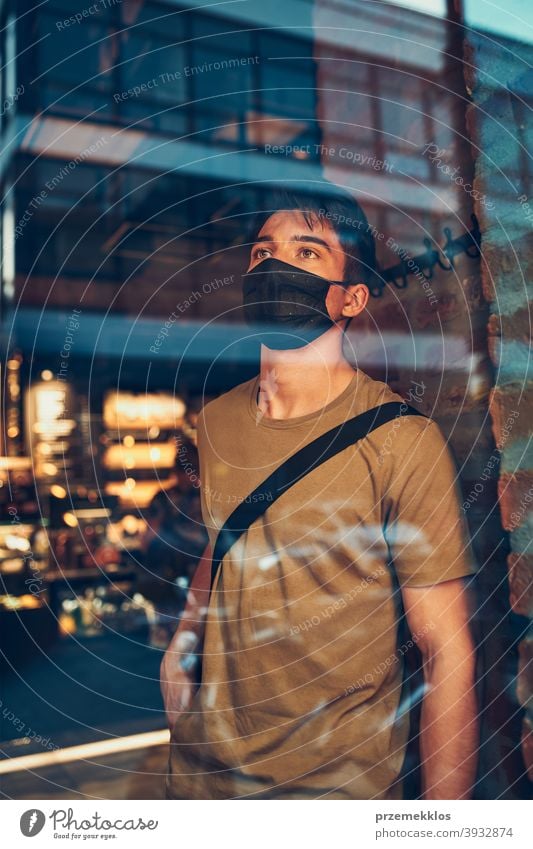 Young man standing in coffee shop at store front in the city center, wearing the face mask to avoid virus infection caucasian conversation covid-19 lifestyle