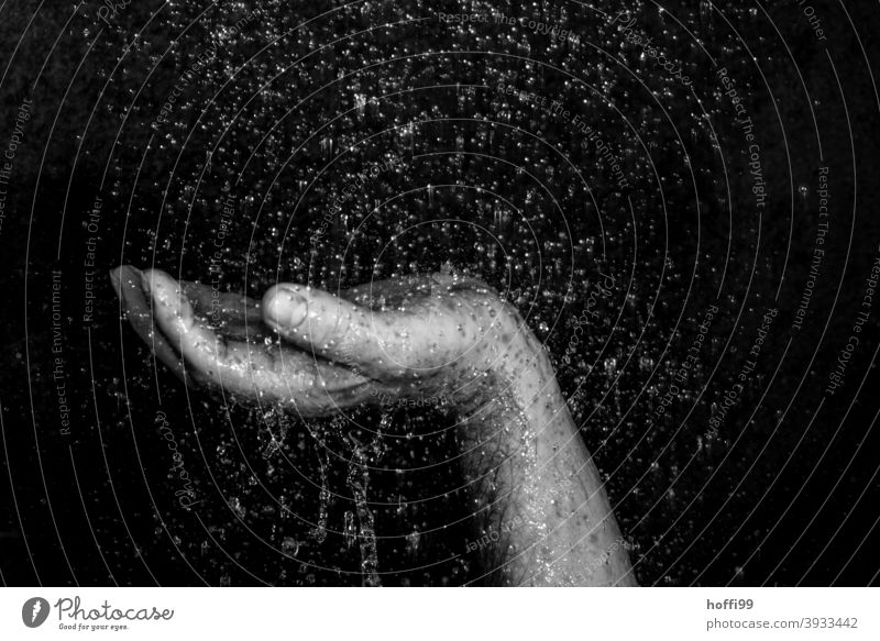 Close-up of a raised hand surrounded by drops of water Hand raised hands Parts of body raindrops Frustration tropics Drops of water powerless uplifted hand