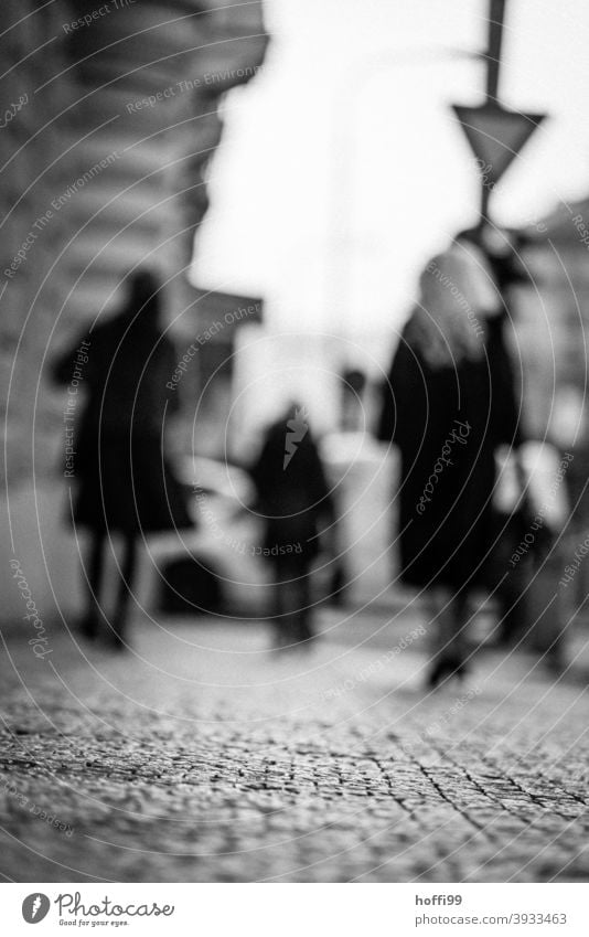 blurred pedestrians on a paved footpath Passers-by Sidewalk dreariness blurred background people Group Paving stone Cobbled pathway Lanes & trails Stone