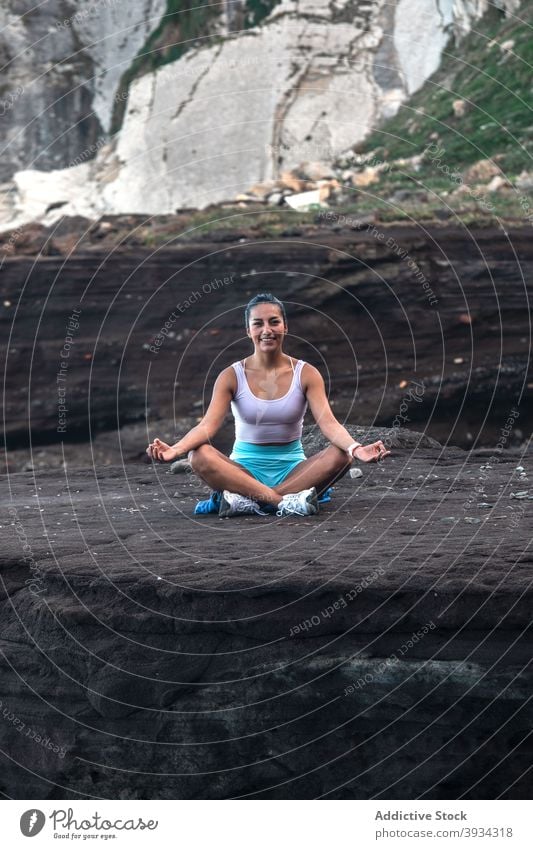 Relaxed woman doing yoga in Lotus pose on seashore lotus pose meditate beach padmasana mudra mindfulness zen female peaceful harmony practice healthy balance