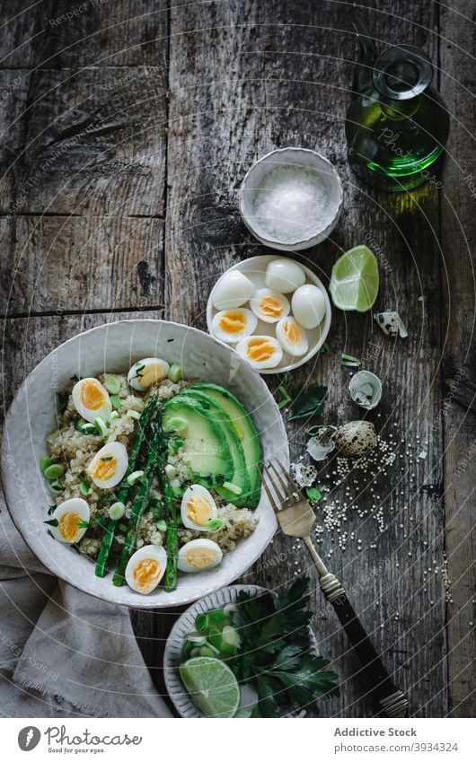 Tasty quinoa salad with avocado and eggs served on table in kitchen asparagus healthy ingredient bowl meal fresh healthy food delicious vitamin wooden fruit