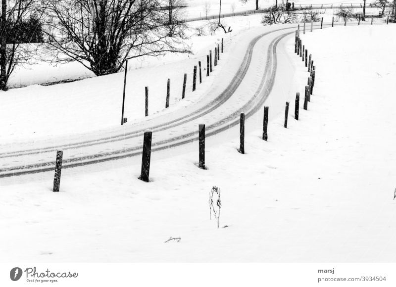 Road secured with track posts, so that everyone knows where they have to drive through and not get off the track. Tire tracks in S-shape. slippery