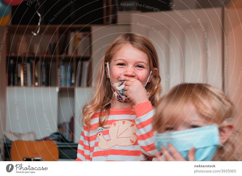 Sibling Sisters Smiling with Face Masks mask child sisters kid children female girl Indoor home at home siblings back to back caucasian face mask protective