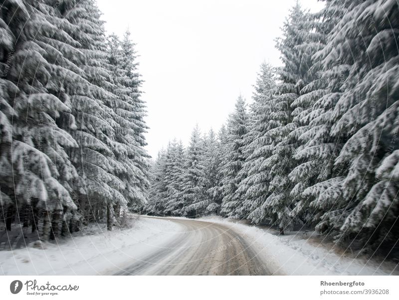 slippery snow covered road in a forest area Street Snow Forest firs conifers Winter Landscape Nature Winter maintenance program broaching Push Salt smooth peril