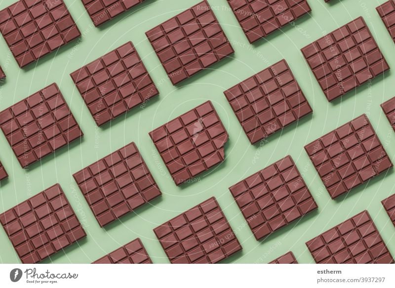 Geometric pattern made with chocolate bars and in the center a bitten tablet geometric pattern milk chocolate yummy confectionery broken antioxidan cacao powder