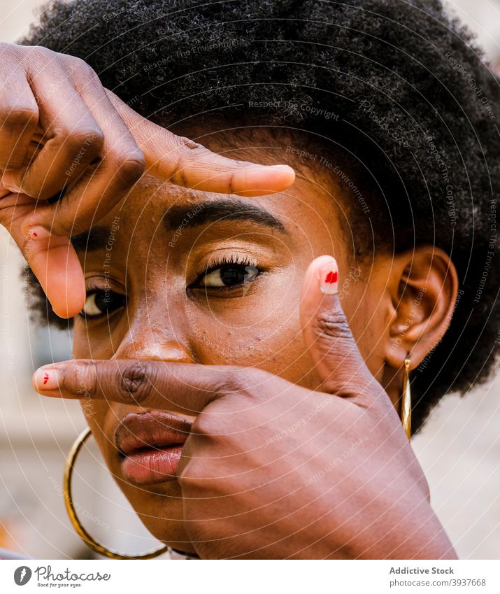 Black woman making frame with fingers afro curly hair serious portrait shoot young photography female african american black ethnic gesture style appearance