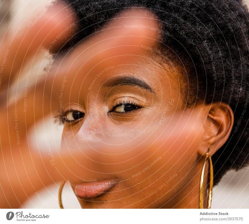 Black woman outstretching hand towards camera style curly hair afro reach serious young urban female ethnic african american black millennial trendy appearance