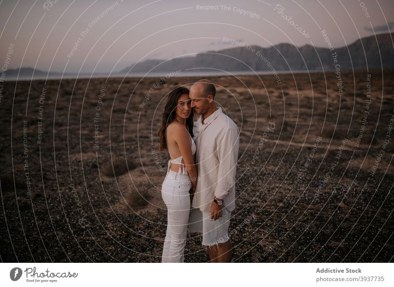 Couple standing back to back in nature couple love peaceful savanna evening twilight white outfit touch together boyfriend relationship tender calm girlfriend