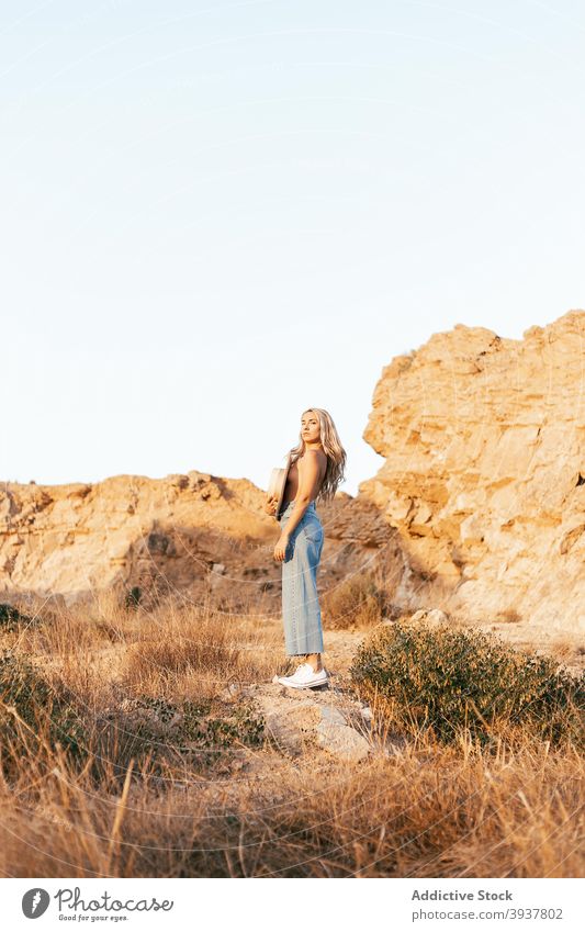 Naked woman covering breast with hat in nature slim topless tranquil enjoy sunset style female jeans relax harmony stand summer naked serene calm evening young