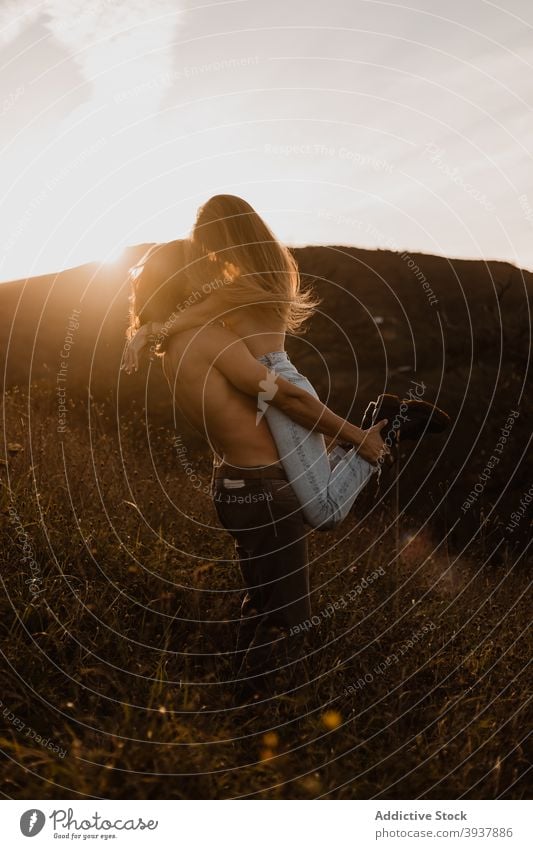 Couple with naked torsos hugging in field couple embrace sunset together love lift relationship boyfriend topless foreplay girlfriend shirtless tender fondness