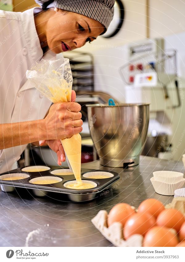 Chef preparing muffins in kitchen confectionery pastry chef dough prepare professional fill bag culinary cook food woman cuisine work process job occupation