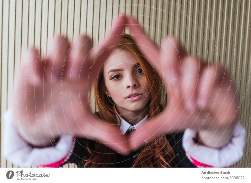 Tranquil woman looking at the camera and making shapes with his hands hopeful sunbeam room serene concept dreamy harmony female style tranquil think silent