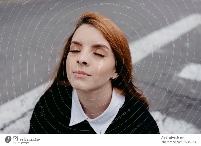 Woman with wind in hair on street redhead woman flying hair carefree charming red hair enjoy smile female content young ginger cheerful city style positive