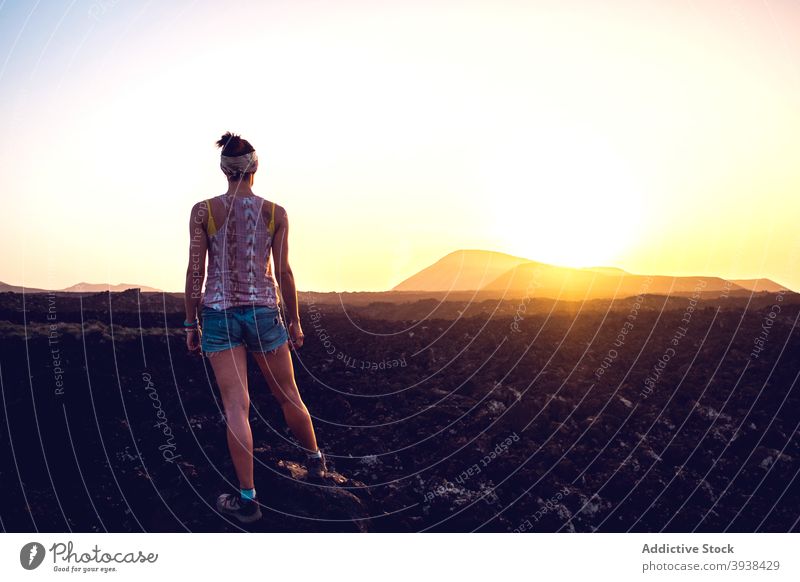 Anonymous woman enjoying mountain landscape during hiking trip at sunset relax admire recreation hike traveler wanderlust nature scenery female fit casual rocky