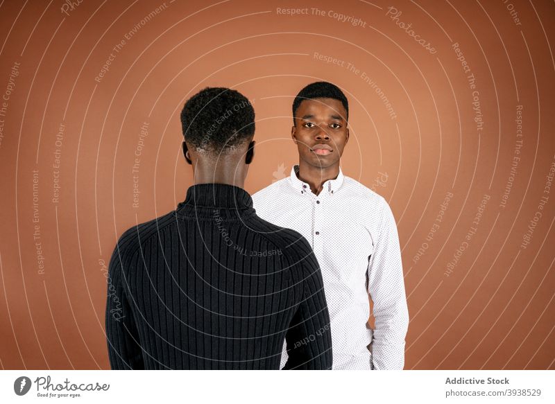 Black men standing in studio together casual outfit model style confident serious handsome male black ethnic african american calm masculine arms crossed