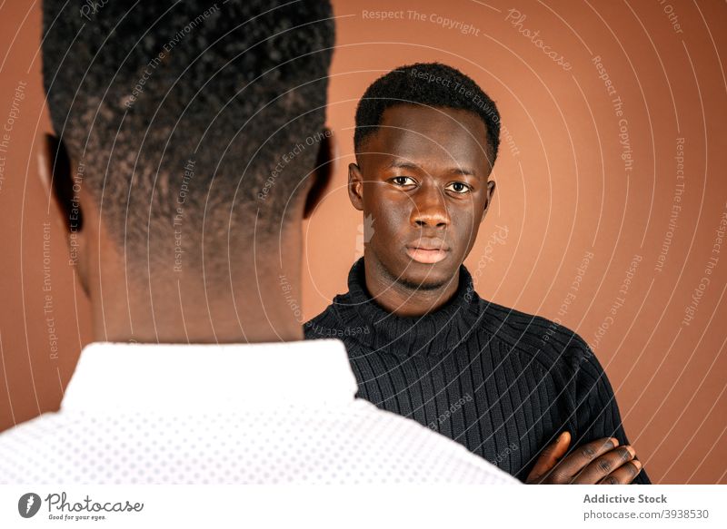 Black men standing in studio together casual outfit model style confident serious handsome male black ethnic african american calm masculine arms crossed