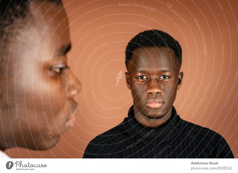 Black men standing in studio together casual outfit model style confident serious handsome male black ethnic african american calm masculine arms crossed