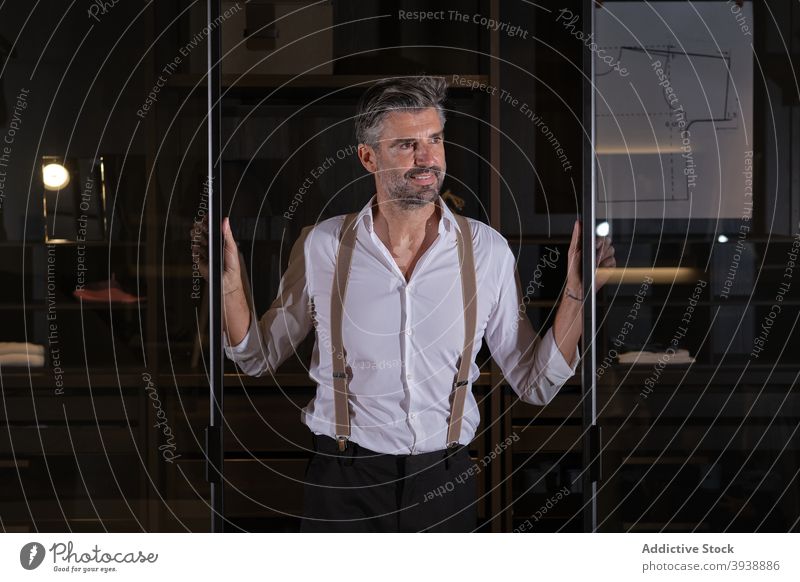 Business Man in Dressing Room suspenders looking to the side suit elegance elegant portrait posing middle aged man beard grey hair smiling smile happy