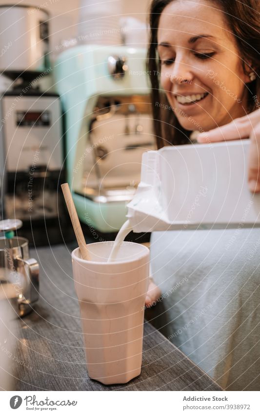 Woman preparing milkshake in cafe prepare woman bartender drink beverage pour cafeteria female counter smile cheerful barista job work add small business