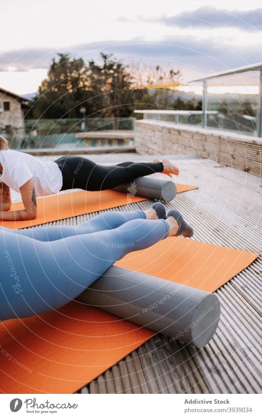 Women doing yoga in High Cobra poses on terrace women practice corba pose asana flexible pilates slim mat stretch female foam roller wellness bhujangasana relax