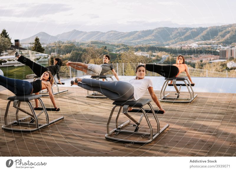 Group of people during pilates workout class chair exercise group abs abdomen company sportswear terrace training physical wellbeing fitness wellness healthy