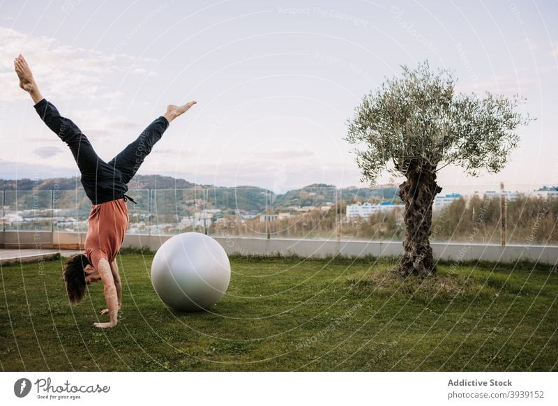 Man doing yoga in Wild Thing poses on fit balls pilates wild thing pose balance asana together flexible camatkarasana stretch lawn sportswear exercise wellness