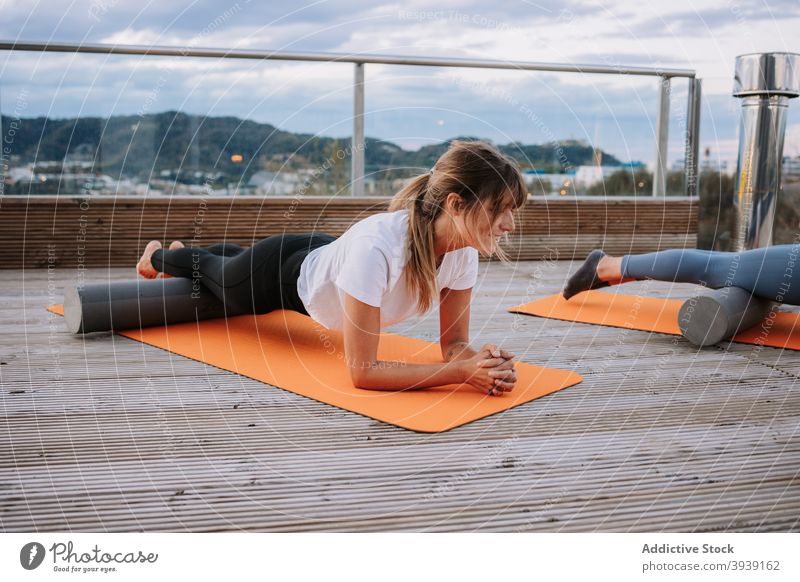 Women doing yoga in High Cobra poses on terrace women practice corba pose asana flexible pilates slim mat stretch female foam roller wellness bhujangasana relax