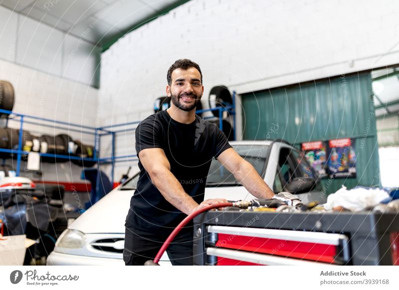 Busy mechanic with tool cabinet in car workshop man technician service instrument station male job garage maintenance repair glove handyman auto occupation