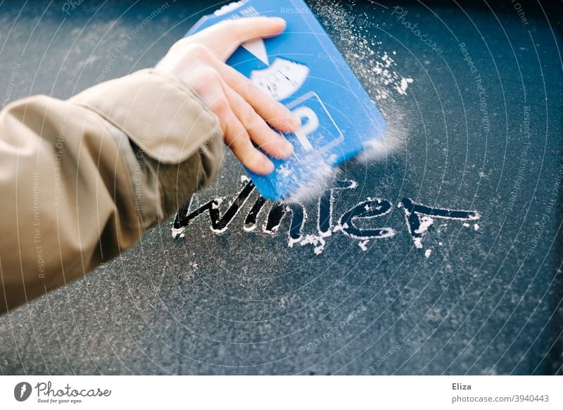 Hand scrapes the icy car window free with an ice scraper on which the word winter is written Car window Frost Ice Winter Free Scratch Slice Frozen iced