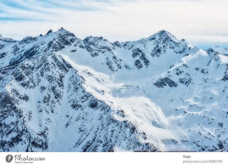 Snowy blue mountains in clouds winter sky snow white caucasus alps elbrus ice nature high peak landscape glacier cold beautiful alpine ski sun travel resort top