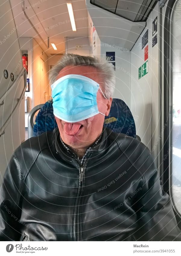 Man with mouth and nose protection covers his face in a public transport vehicle 65-75 years covid 19 corona Colour photo Ignorant Interior shot