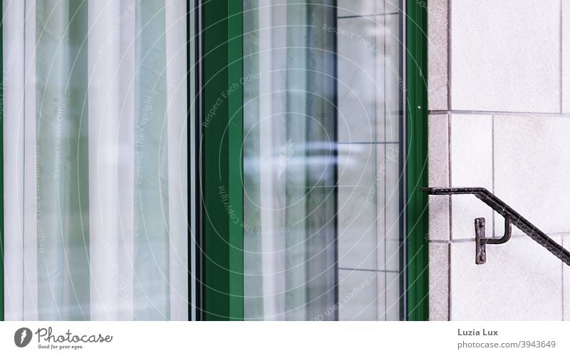 Striped - the green door of a closed shop, behind it a striped curtain, on the right an old-fashioned brown handrail Store premises Load Handlebar Trade