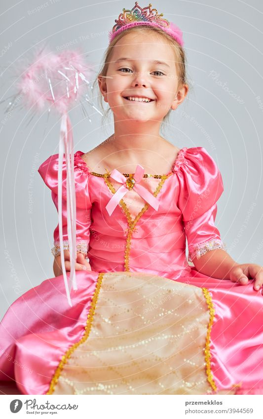 Little girl enjoying her role of princess. Adorable cute 5-6 years old girl wearing pink princess dress and tiara fairy child festival lifestyle joyful smiling