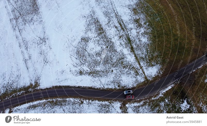 Drone photo of two cars passing each other in winter on a narrow road Aerial photograph drone photo Winter Street Driving Snow Sun Shadow Light Dark Warmth