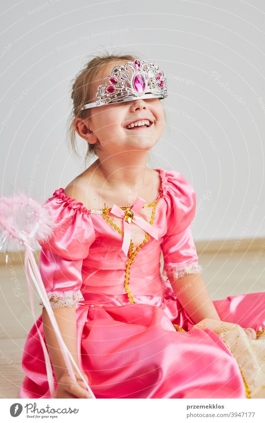 Little girl enjoying her role of princess. Adorable cute 5-6 years old girl wearing pink princess dress and tiara fairy child festival lifestyle joyful smiling