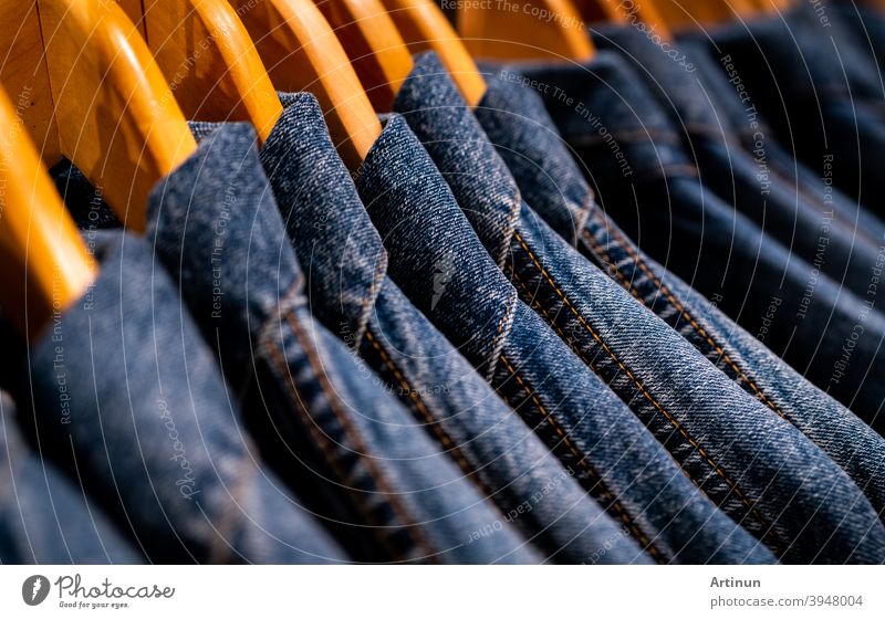 Selective focus on jacket jeans hanging on rack in clothes shop. Denim jeans with jeans pattern. Textile industry. Jeans fashion and shopping concept. Clothing concept. Denim jacket on rack for sale.