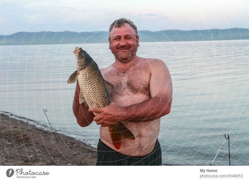 Stocky man with big carp. Khakassia, Russia autumn background beach beautiful blue camp catch fish fisherman fishing gold happy hobby lucky nature outdoor