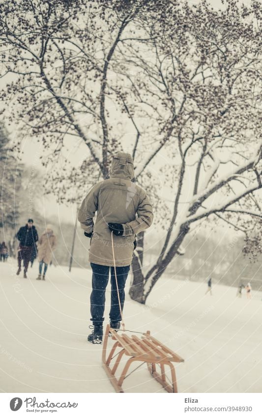 A man pulls a sled through the snow. Winter atmosphere. Sleigh Pull Landscape wood sledges winter landscape Snow Winter mood Snowscape Cold out Nature trees Man