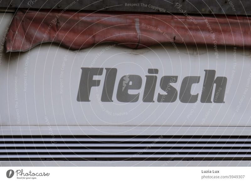 Meat - sign of a butcher's shop, only partially legible; above it an old awning in washed-out blood red Butchery Red Blood Red Sun blind Old Exterior shot