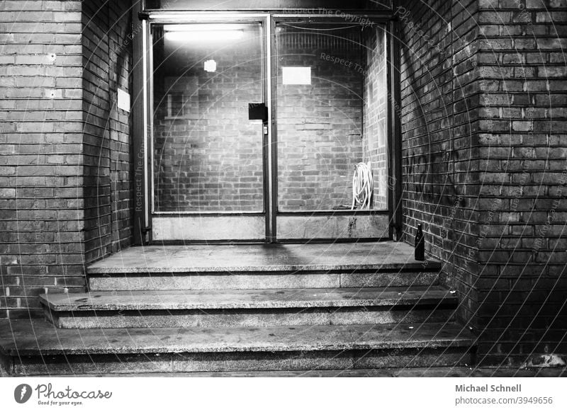 Entrance glass door of a brick office building with a beer bottle in front of it Glass door Front door Deserted Exterior shot House (Residential Structure)