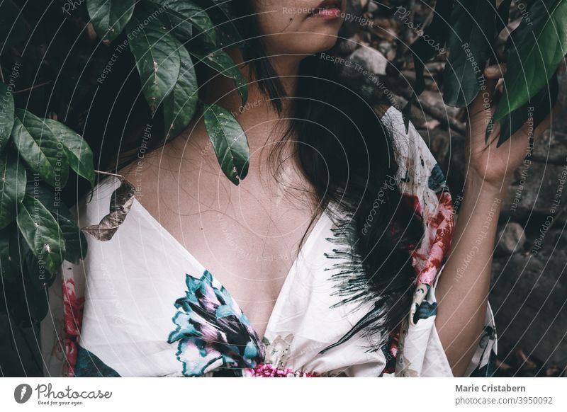 Portrait of a woman in floral dress against tropical leaves summer spring portrait outdoor feminine moody pink contentment youth hairstyle summertime skincare