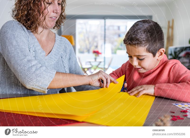 Mother and son  making crafts with cardboards  at home. activity adorable adult birthday birthday crown child childhood classroom colorful creative cut cute