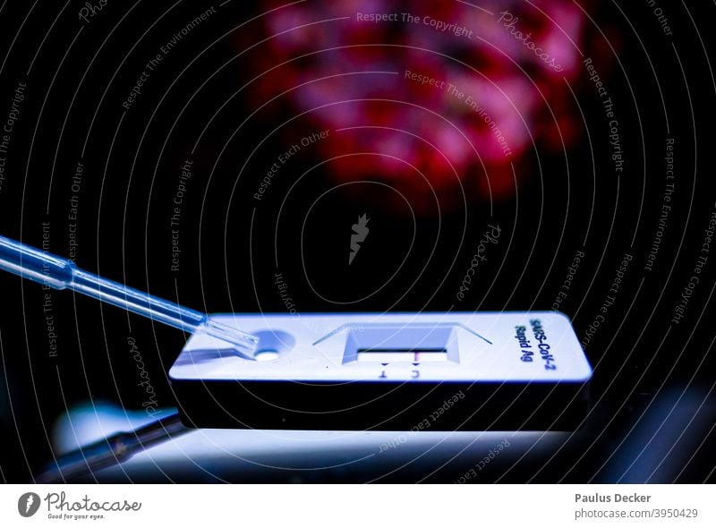 Corona rapid test with pipette in front of an image of a coronavirus Quick test covid-19 Laboratory Risk of infection prevention COVID Epidemic pandemic Healthy