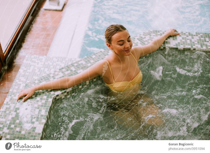 Young woman relaxing in the whirlpool bathtub at the poolside young body spa relaxation water adult beauty bubble people person care hot hydrotherapy health