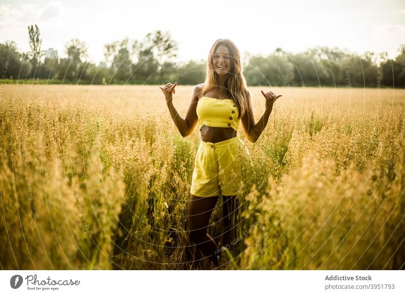 Woman showing shaka gesture in field woman cheerful sign symbol summer park nature female salburua vitoria gasteiz spain yellow outfit optimist positive glad